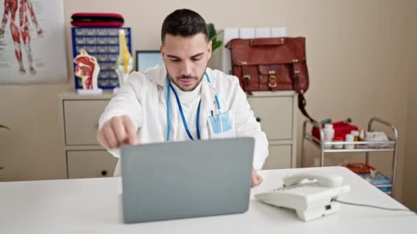 Jovem Hispânico Homem Médico Usando Laptop Trabalhando Clínica — Vídeo de Stock