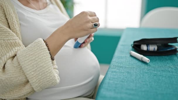 Молодая Беременная Женщина Измеряет Уровень Глюкозы Сидя Столом Столовой — стоковое видео