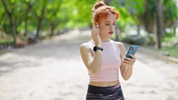 Mujer Pelirroja Joven Mirando Reloj Usando Smartphone Parque — Vídeo de stock