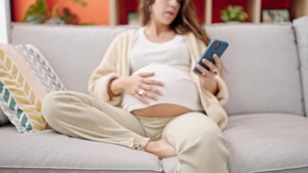 Femeie Însărcinată Care Folosește Smartphone Atingând Burta Acasă — Videoclip de stoc