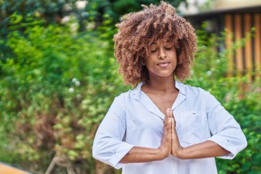 Afrikalı Amerikalı kadın parkta yoga egzersizi yapıyor.