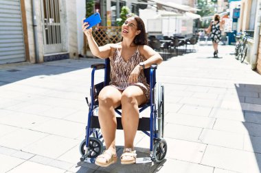 Genç ve güzel İspanyol kadın akıllı telefonuyla selfie çekiyor.