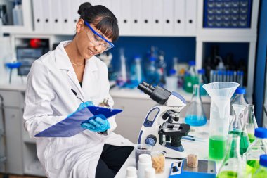 Genç ve güzel İspanyol bilim kadını. Laboratuvarda kendine güveni tam bir yazı.