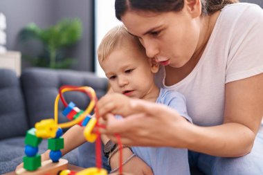 Mother and son sitting on sofa playing at home