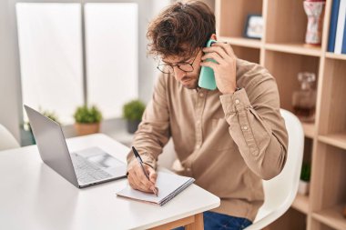 Genç iş adamı, ofisteki not defterine akıllı telefon yazısıyla konuşuyor.