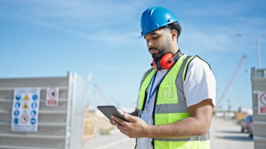 Sokakta dokunmatik ped kullanan Afrikalı Amerikalı bir inşaatçı.