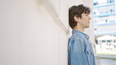 Genç İspanyol üniversitede rahat bir ifadeyle yan tarafa bakıyor.