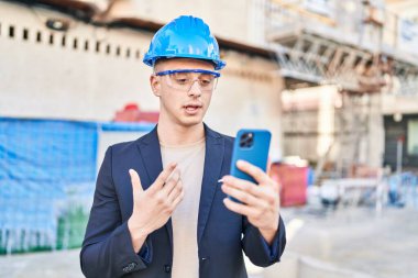 Young hispanic man architect having video call at street
