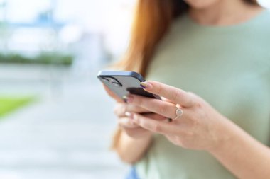 Sokakta akıllı telefon kullanan güzel bir kadın.