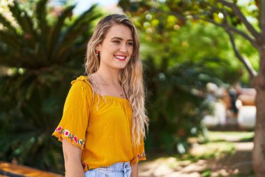 Young woman smiling confident looking to the side at park