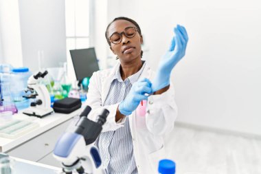 African american woman scientist wearing gloves at laboratory
