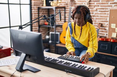 Afrikalı Amerikalı kadın müzisyen müzik stüdyosunda DJ seansı yapıyor.