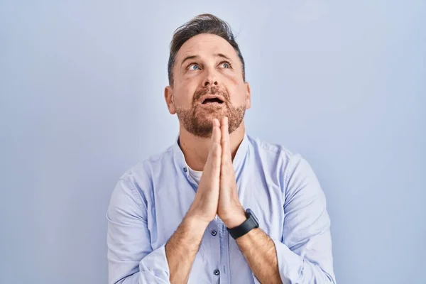 Homem Caucasiano Meia Idade Sobre Fundo Azul Implorando Orando Com — Fotografia de Stock