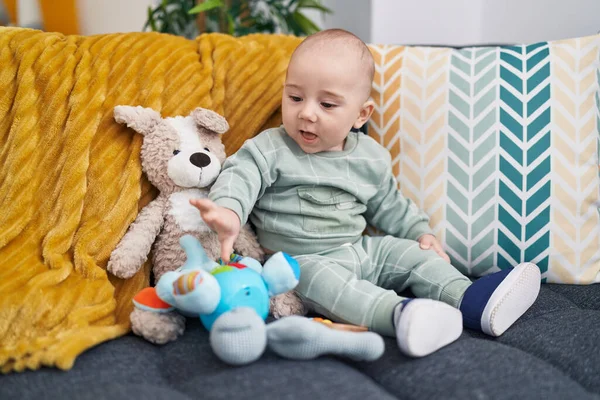 Adorável Bebê Caucasiano Sentado Sofá Com Bonecas Casa — Fotografia de Stock
