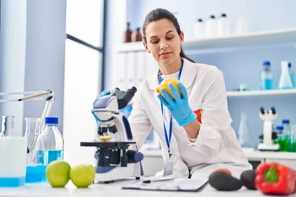 Young Beautiful Hispanic Woman Scientist Using Microscope Holding Lemon Laboratory — Photo