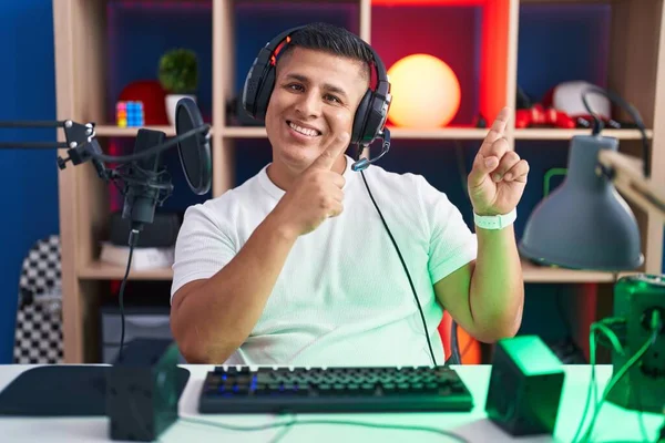 Young Hispanic Man Playing Video Games Smiling Looking Camera Pointing — Stok fotoğraf