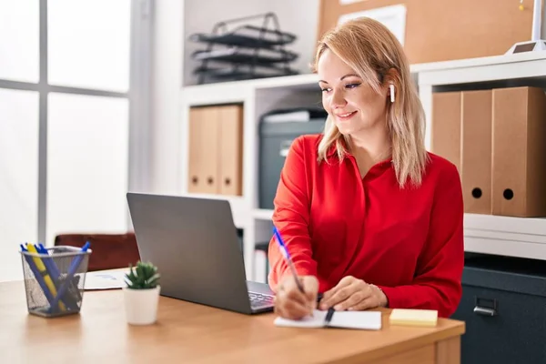 若いブロンドの女性のビジネスワーカーを使用してノートパソコンでノートパソコンの書き込みでオフィス — ストック写真