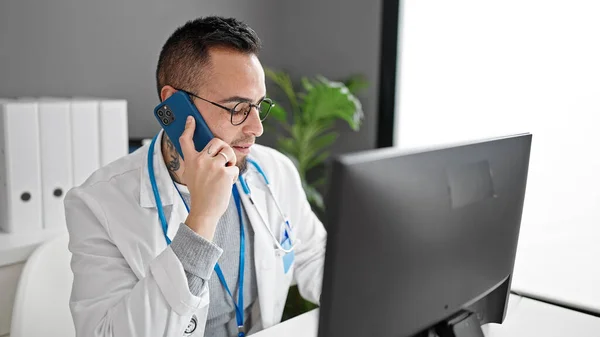 Latynoski Lekarz Rozmawiający Przez Telefon Przez Komputer Klinice — Zdjęcie stockowe