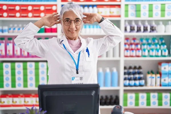 Middle Age Woman Tattoos Working Pharmacy Drugstore Smiling Pulling Ears — Stock Photo, Image