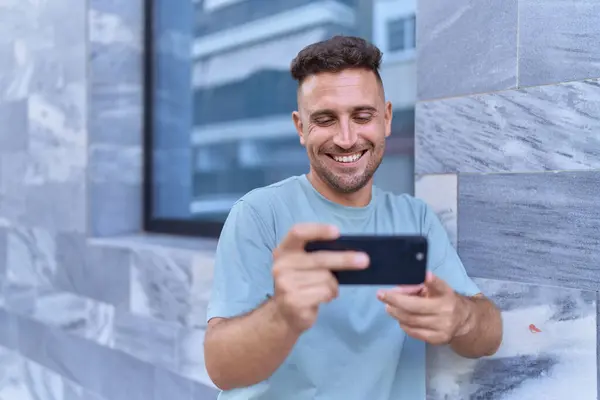 Joven Hombre Hispano Sonriendo Confiado Viendo Video Smartphone Calle —  Fotos de Stock