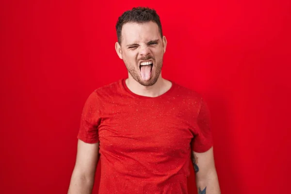 Young Hispanic Man Standing Red Background Sticking Tongue Out Happy — Stock Photo, Image
