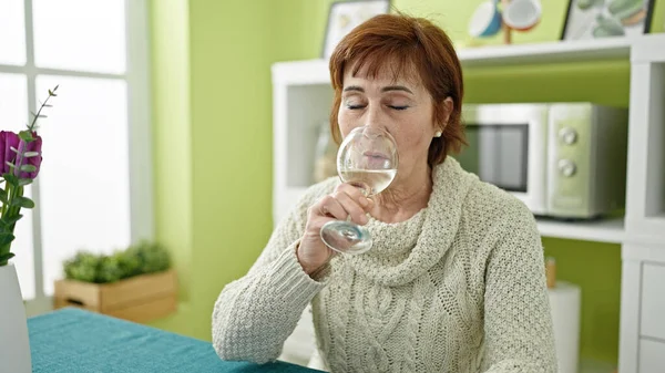 Ältere Hispanische Frau Sitzt Auf Dem Tisch Und Trinkt Weißwein — Stockfoto