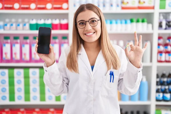 Mujer Rubia Joven Que Trabaja Farmacia Mostrando Pantalla Del Teléfono —  Fotos de Stock
