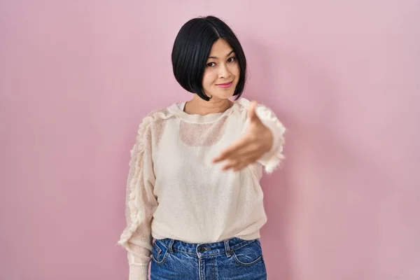 Ung Asiatisk Kvinna Står Över Rosa Bakgrund Ler Vänlig Erbjuder — Stockfoto