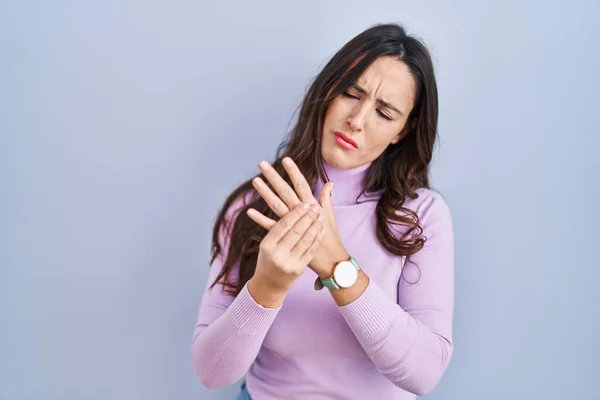 若いですブルネット女性上の青の背景苦しみ痛み上の手と指 関節炎の炎症 — ストック写真
