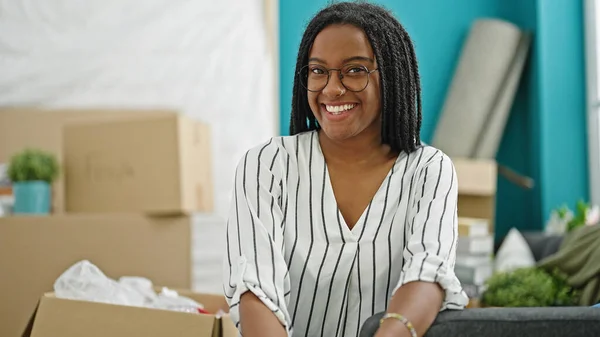 Afro Amerikaanse Vrouw Glimlachen Zelfverzekerd Zitten Bank Nieuw Huis — Stockfoto