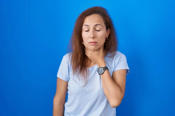 Mujer Morena Pie Sobre Fondo Azul Tocando Doloroso Cuello Dolor —  Fotos de Stock