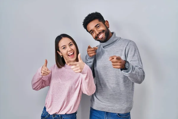 stock image Young hispanic couple standing together pointing fingers to camera with happy and funny face. good energy and vibes. 