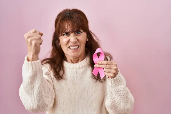 Middle Age Hispanic Woman Holding Pink Cancer Ribbon Annoyed Frustrated — ストック写真