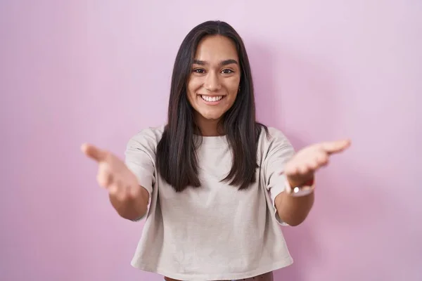 Joven Mujer Hispana Pie Sobre Fondo Rosa Sonriente Alegre Ofreciendo —  Fotos de Stock