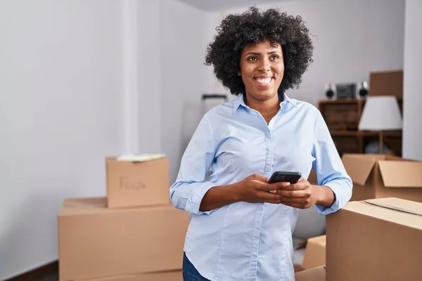 African American Woman Using Smartphone Standing New Home — Stockfoto