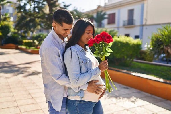 Mladý Latinský Pár Očekává Dítě Překvapení Květinami Parku — Stock fotografie