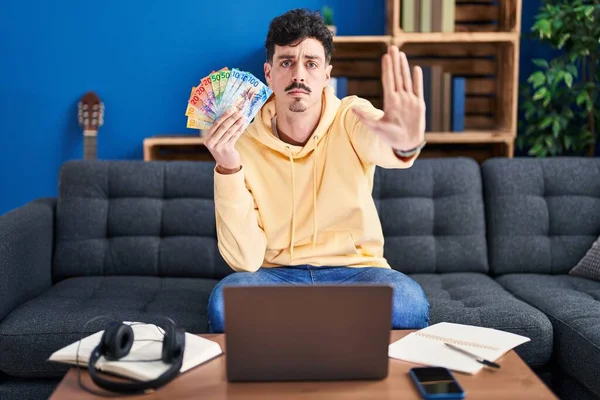 Homem Hispânico Trabalhando Com Laptop Segurando Notas Francos Suíços Com — Fotografia de Stock