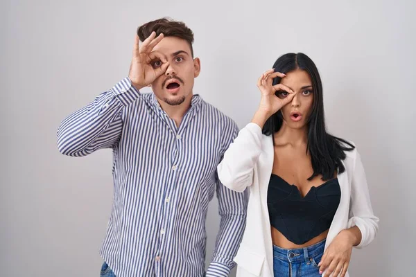 Young Hispanic Couple Standing White Background Doing Gesture Shocked Surprised — Stock Photo, Image
