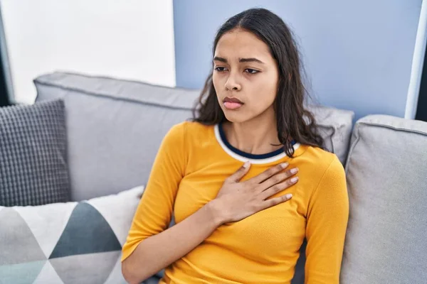 Young African American Woman Stressed Touching Heart Sitting Sofa Home — ストック写真