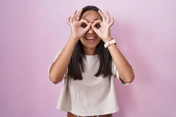 Young Hispanic Woman Standing Pink Background Doing Gesture Binoculars Sticking —  Fotos de Stock