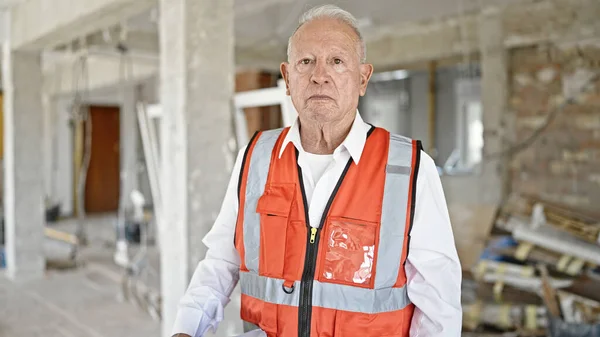 高级灰发男子建筑师站在建筑工地上 表情轻松 — 图库照片