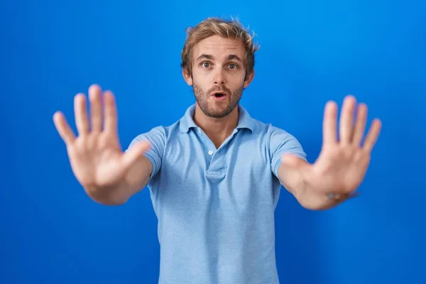 Caucásico Hombre Pie Sobre Fondo Azul Haciendo Stop Gesture Con —  Fotos de Stock