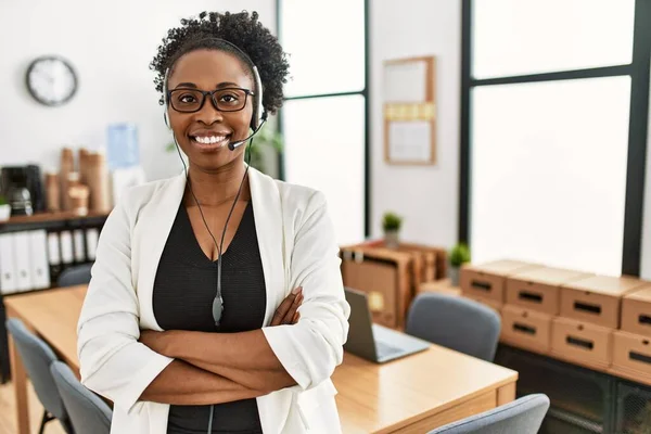 African american woman call center agent smiling confident standing with arms crossed gesture at office