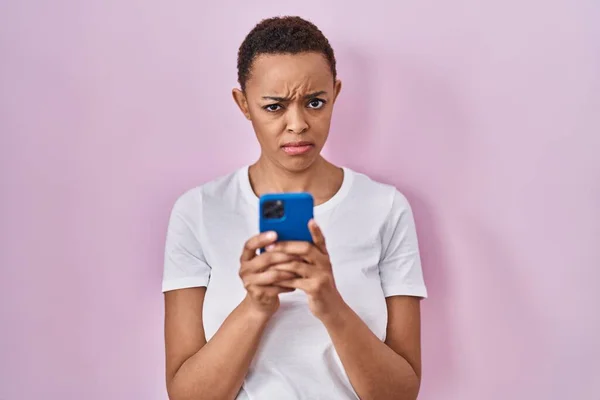 stock image Beautiful african american woman using smartphone skeptic and nervous, frowning upset because of problem. negative person. 