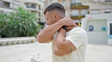 Parkta boyun ağrısı çeken genç bir adam.