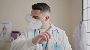 Tıbbi maske takan genç İspanyol doktor klinikte tartışıyor.