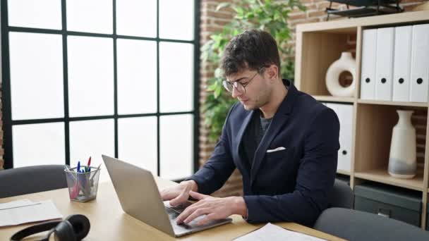 オフィスでお祝いのノートパソコンを使用して若いヒスパニック系の男のビジネスワーカー — ストック動画