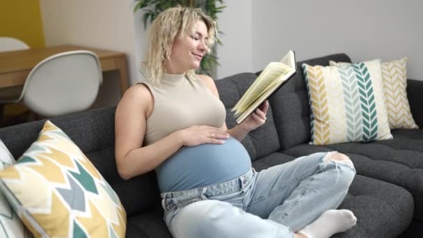 Junge Schwangere Frau Liest Buch Berührt Bauch Hause — Stockvideo