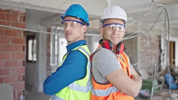 Dois Homens Construtores Sorrindo Confiante Com Braços Cruzados Gesto Canteiro — Vídeo de Stock
