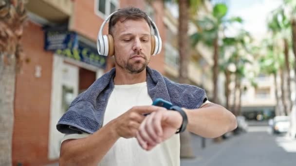 운동복을 거리에서 스마트폰 스마트 워치를 사용하여 음악을 젊은이 — 비디오
